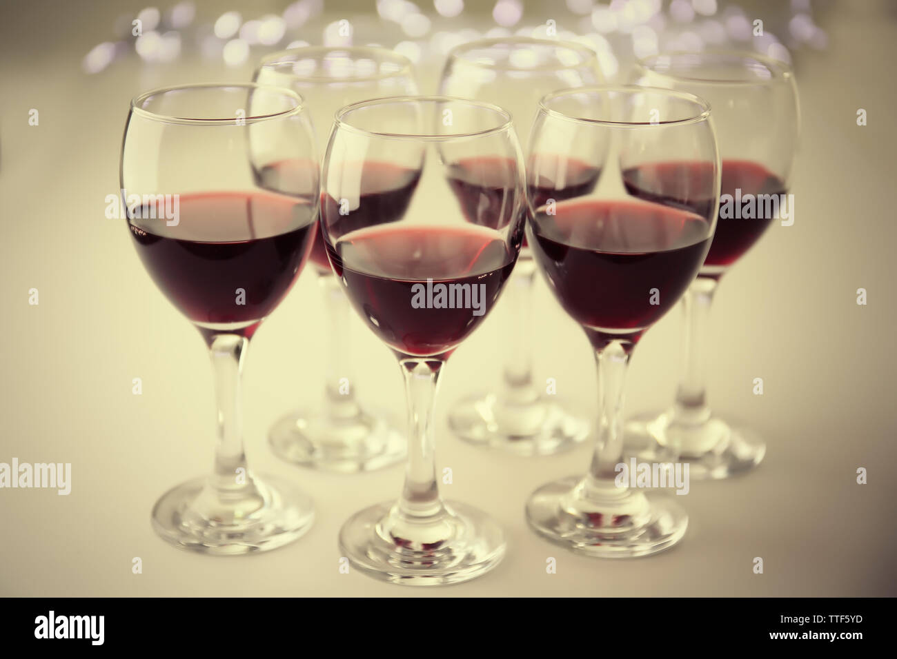 Glasses of red wine on white table closeup Stock Photo - Alamy