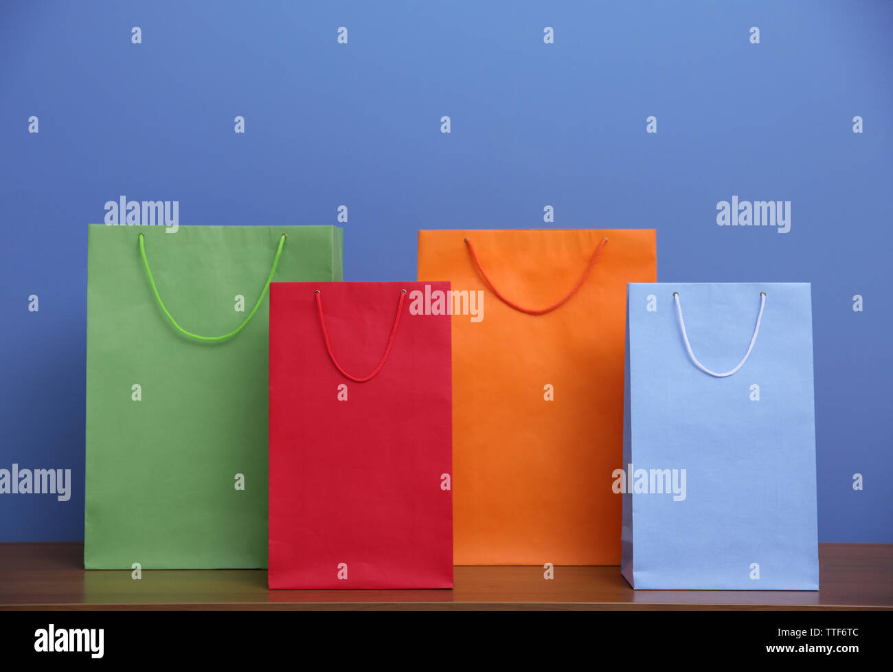 Colored paper bags on blue background Stock Photo Alamy