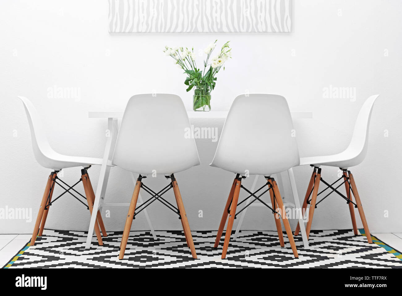 Modern dining room. White chairs and table with bouquet of flowers ...