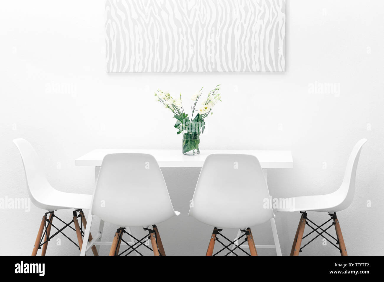 Modern dining room. White chairs and table with bouquet of flowers ...