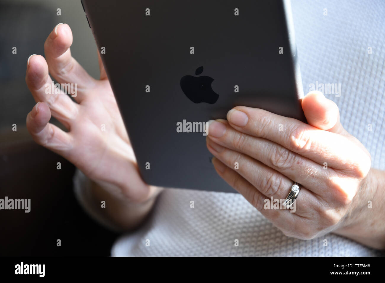 Close up of a senior woman holding an Apple mini  iPad. Stock Photo