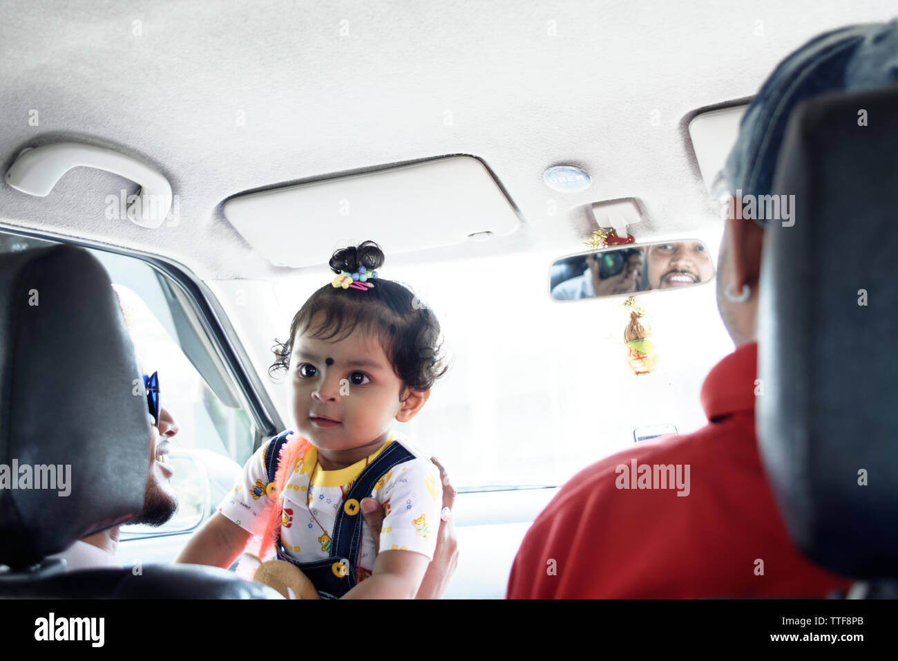 A beautiful Indian baby girl child riding in a car Stock Photo
