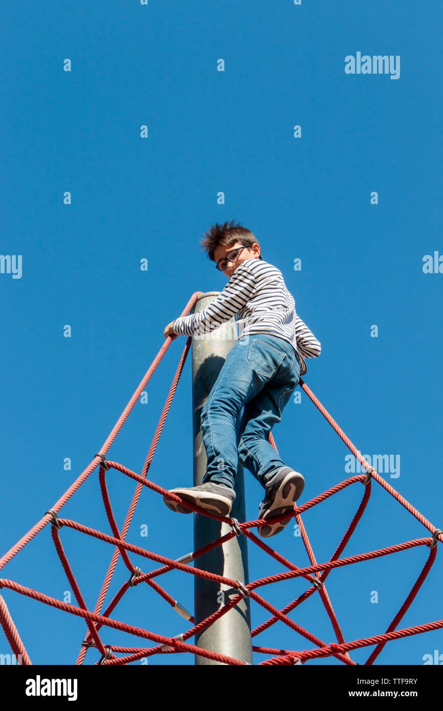 Boy climbing ropes Stock Photo