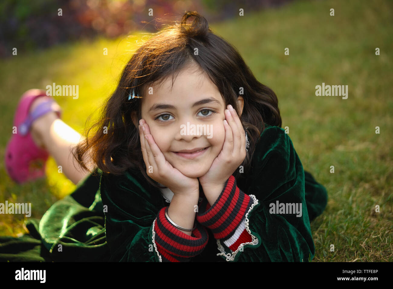 Portrait of a girl lying on grass Stock Photo - Alamy