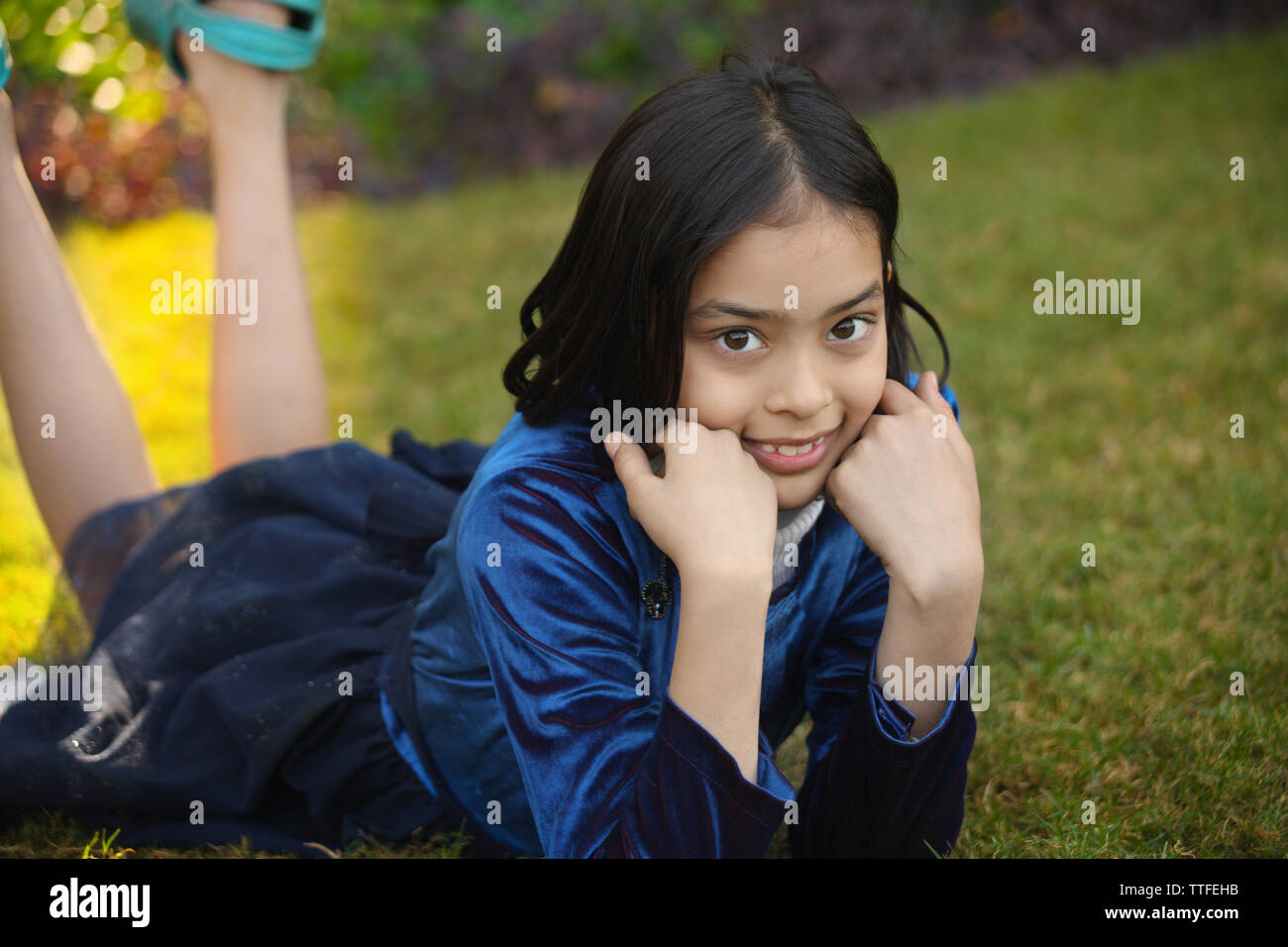 Portrait of a girl lying on grass Stock Photo - Alamy