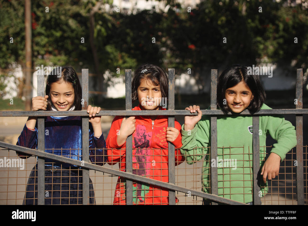 People Standing Behind Railing Three girls standing behind a railing Stock Photo - Alamy