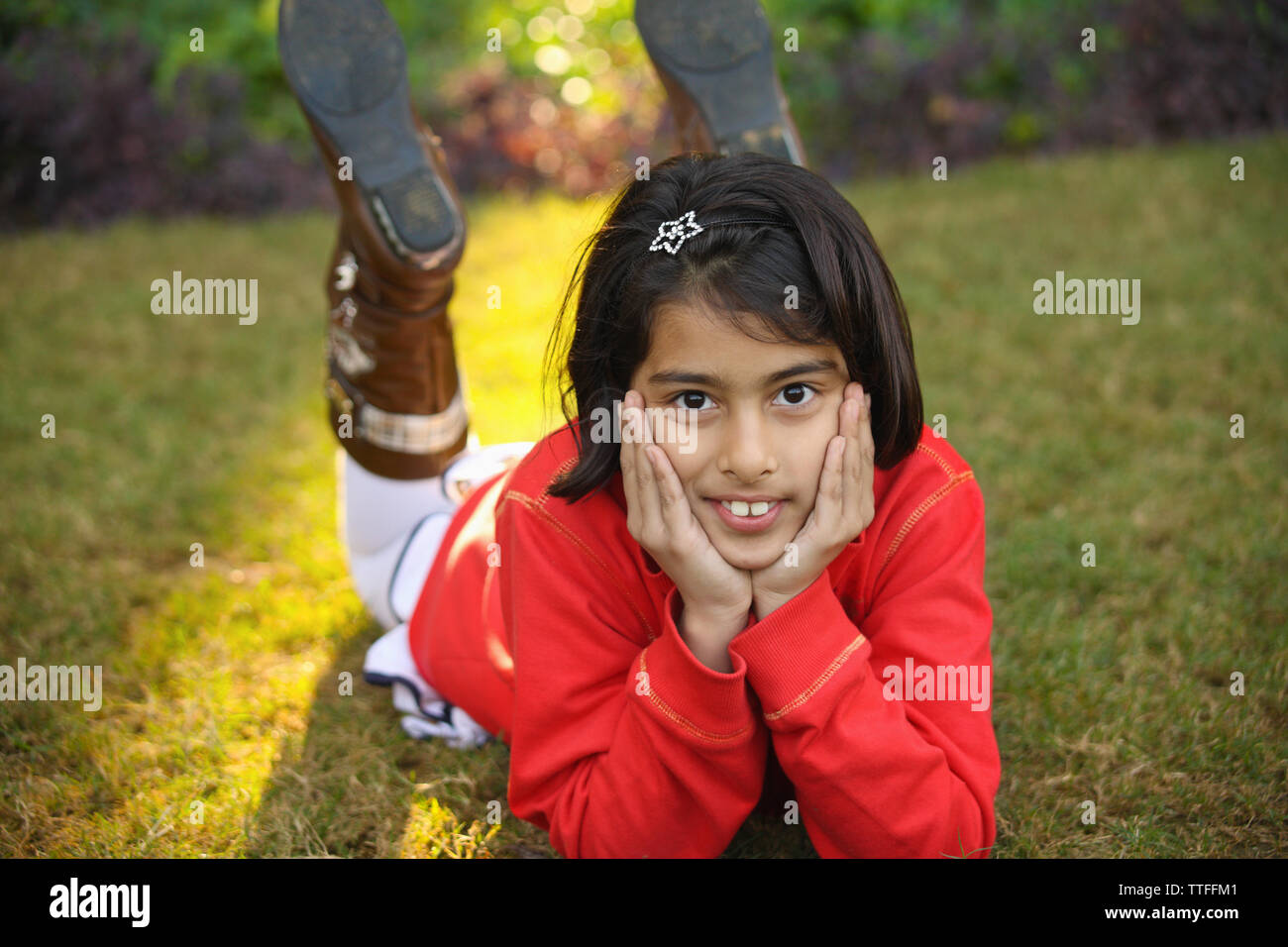 Portrait of a girl lying on grass Stock Photo - Alamy