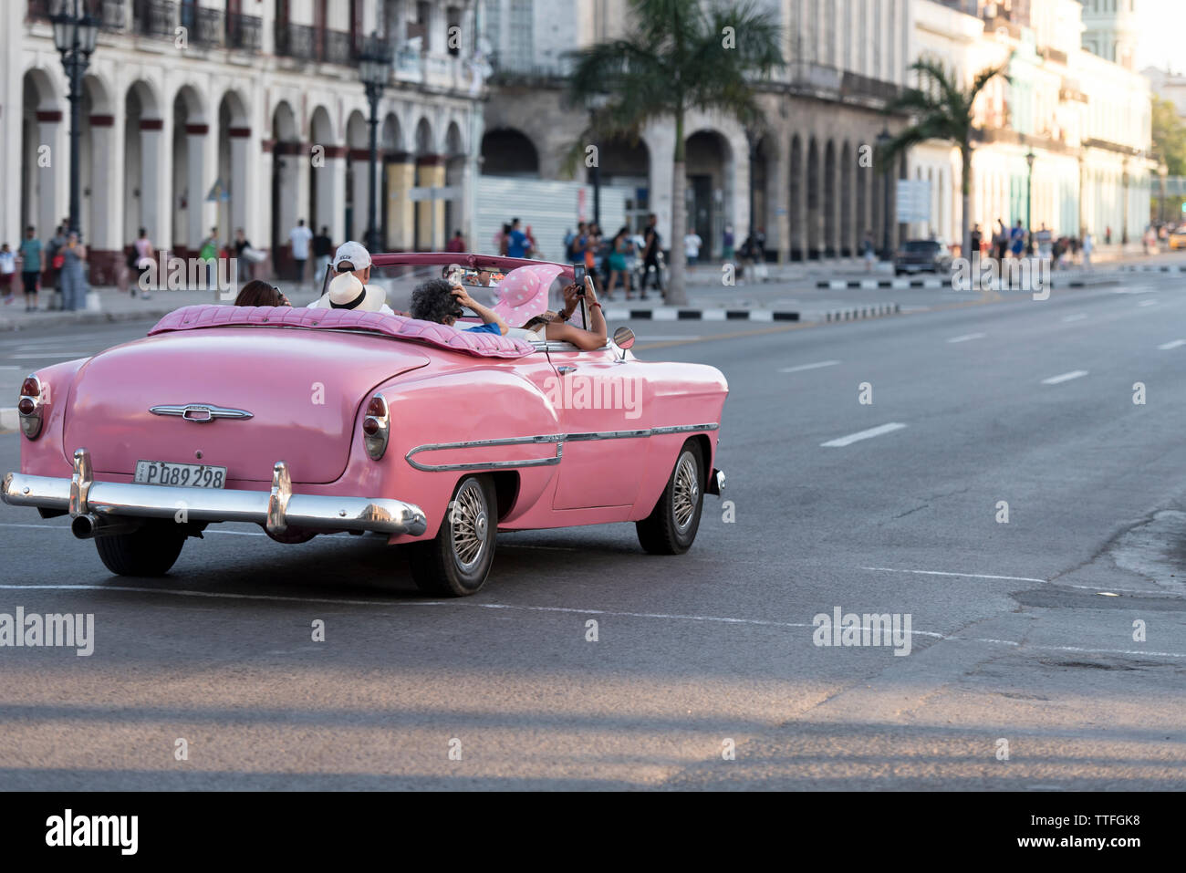 Pink, convertible vintage car driving in the streets of Havana, Cuba. Stock Photo