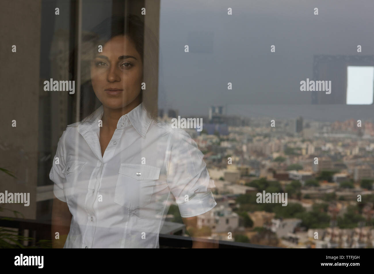 Reflection of a woman in a window glass, Haryana, India Stock Photo