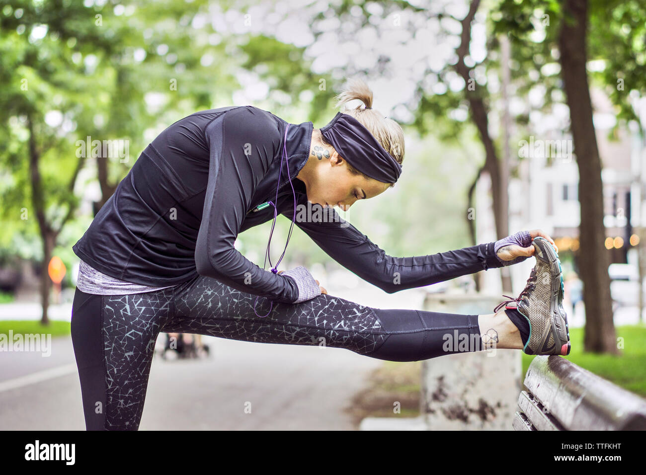 Athletic female stretching leg during daily workout Stock Photo
