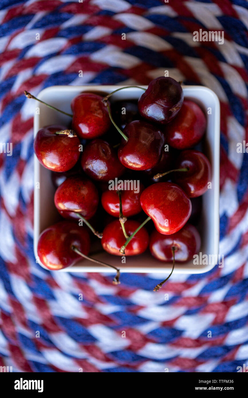 Overhead view of cherries in bowl on place mat Stock Photo