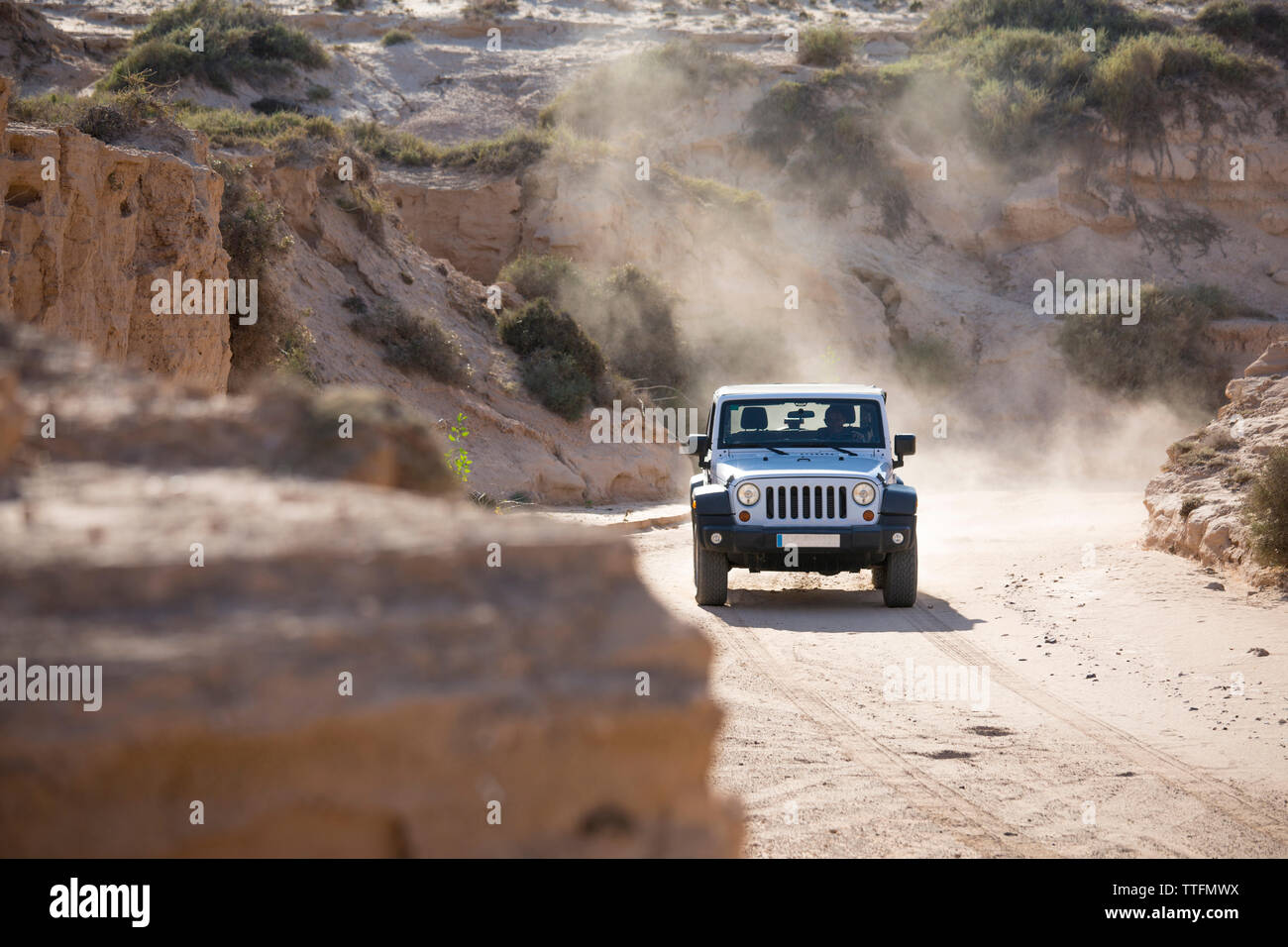 White jeep 4x4 driving off road a empty dusty and sandy dirty road ...