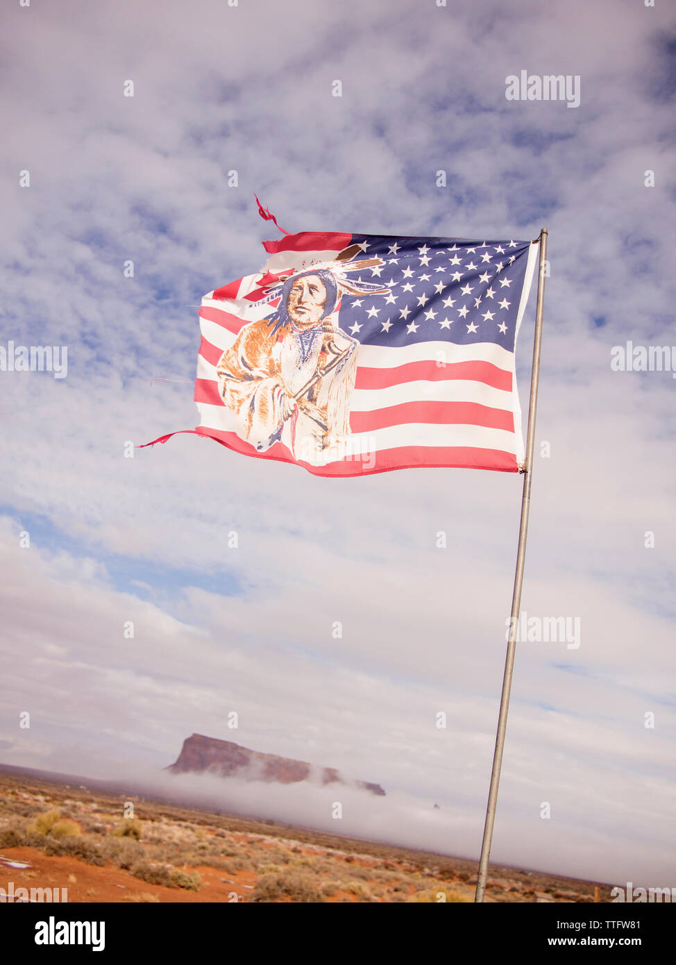 A tattered American flag depicting an Indian blows in the wind. Stock Photo