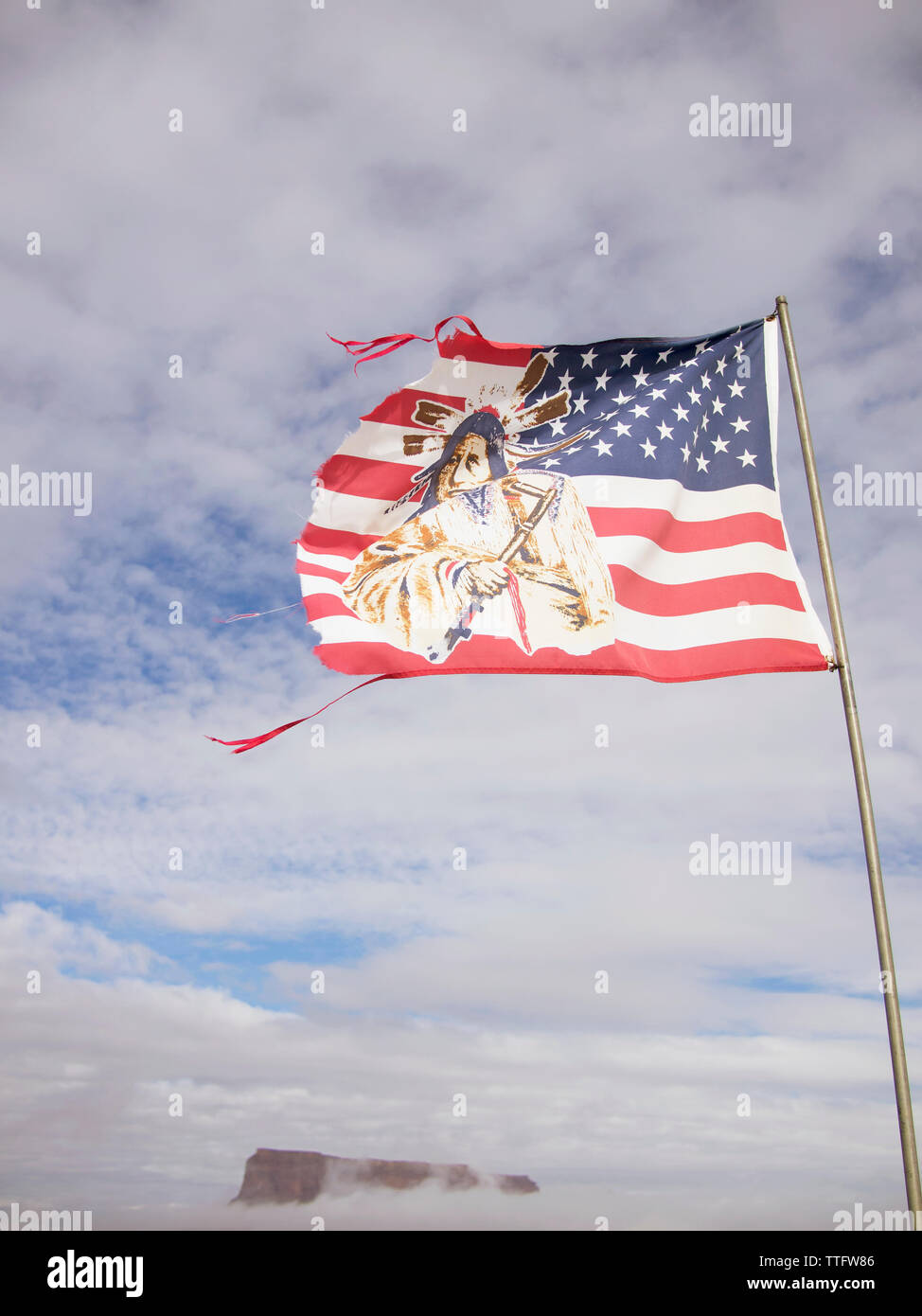 A tattered American flag depicting an Indian blows in the wind. Stock Photo