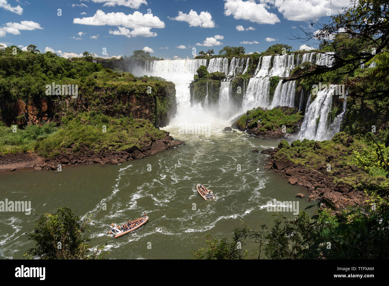 Beautiful landscape of boats riding towards a big powerful waterfall Stock Photo