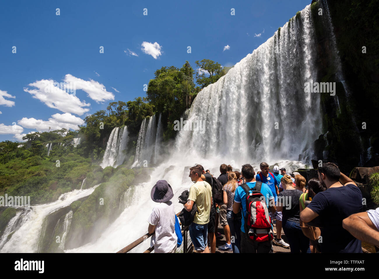 Tourists enjoying beautiful landscape of big waterfalls Stock Photo