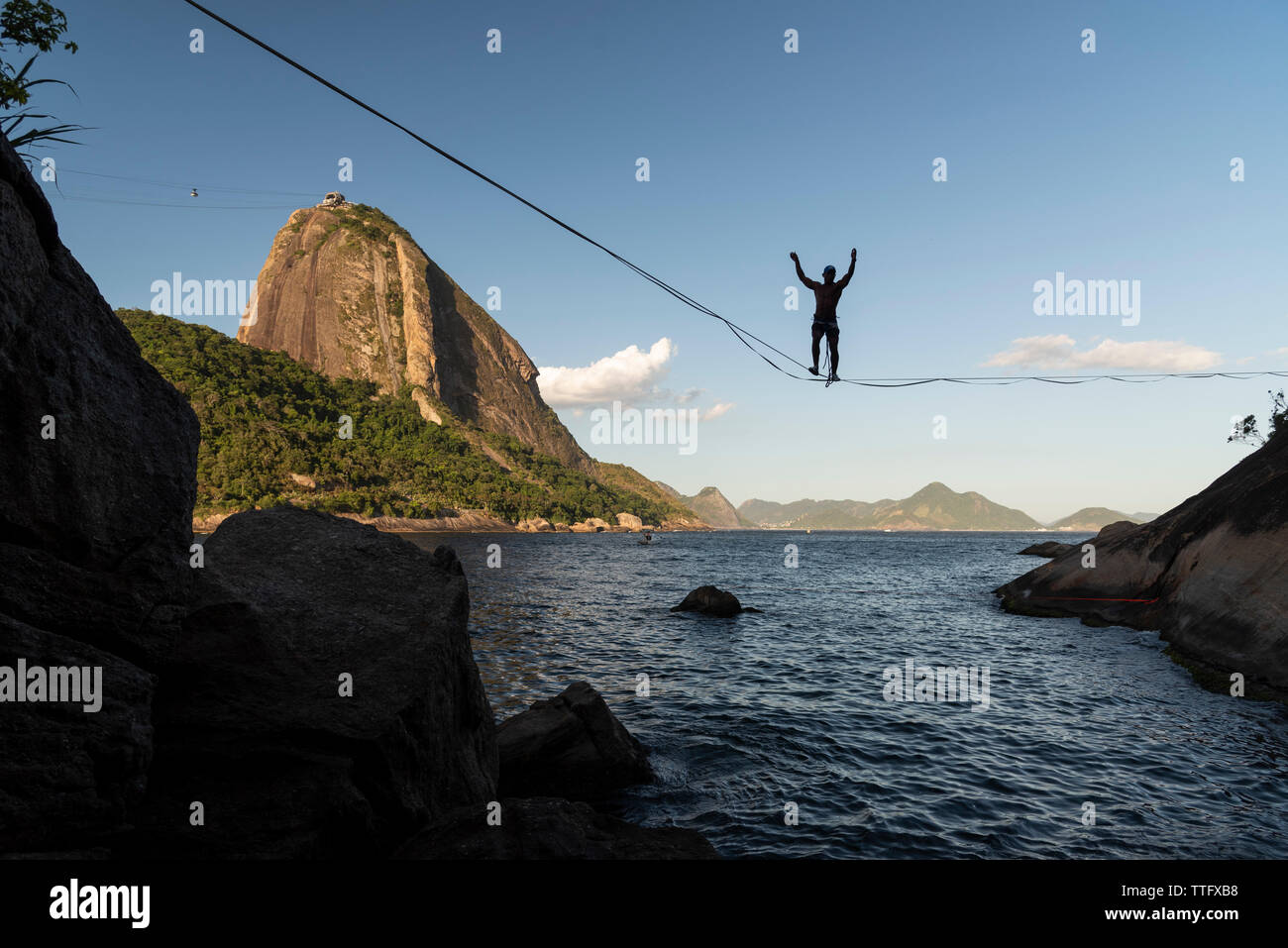 Slackliner wallking the line with Sugar Loaf mountain on the back Stock Photo