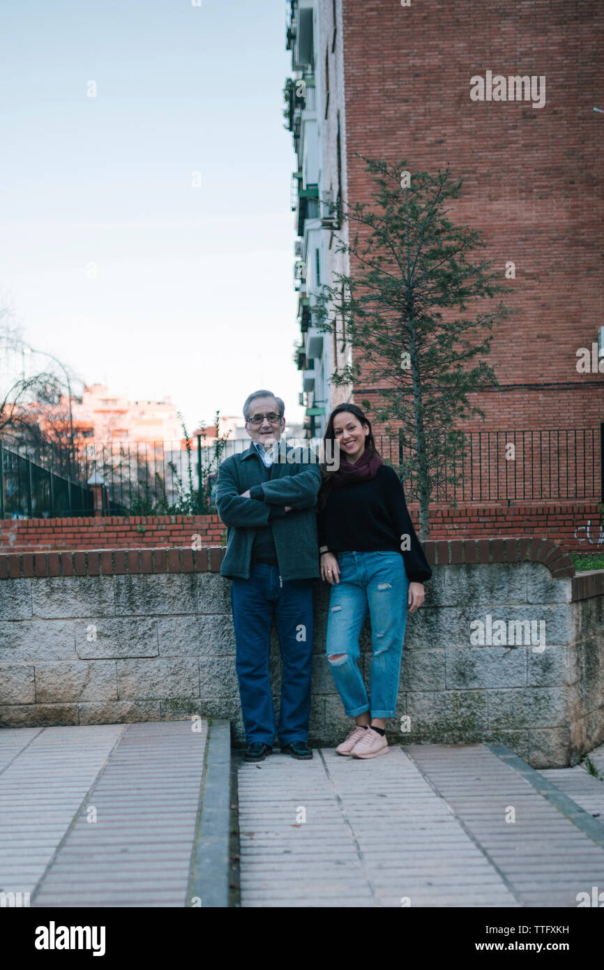 Father and daughter of adult age smile on the street Stock Photo