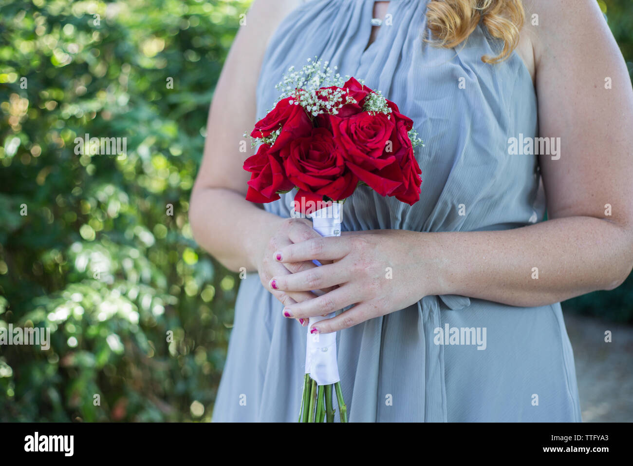 Bridesmaid holding bouqet of roses Stock Photo