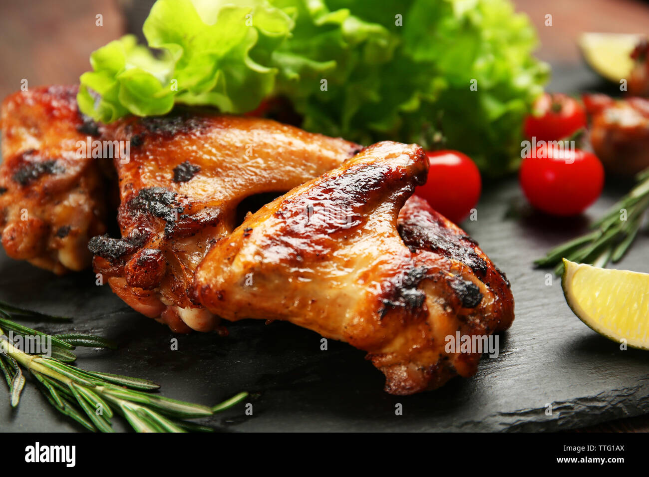 Baked chicken wings with vegetables on slate plate Stock Photo Alamy