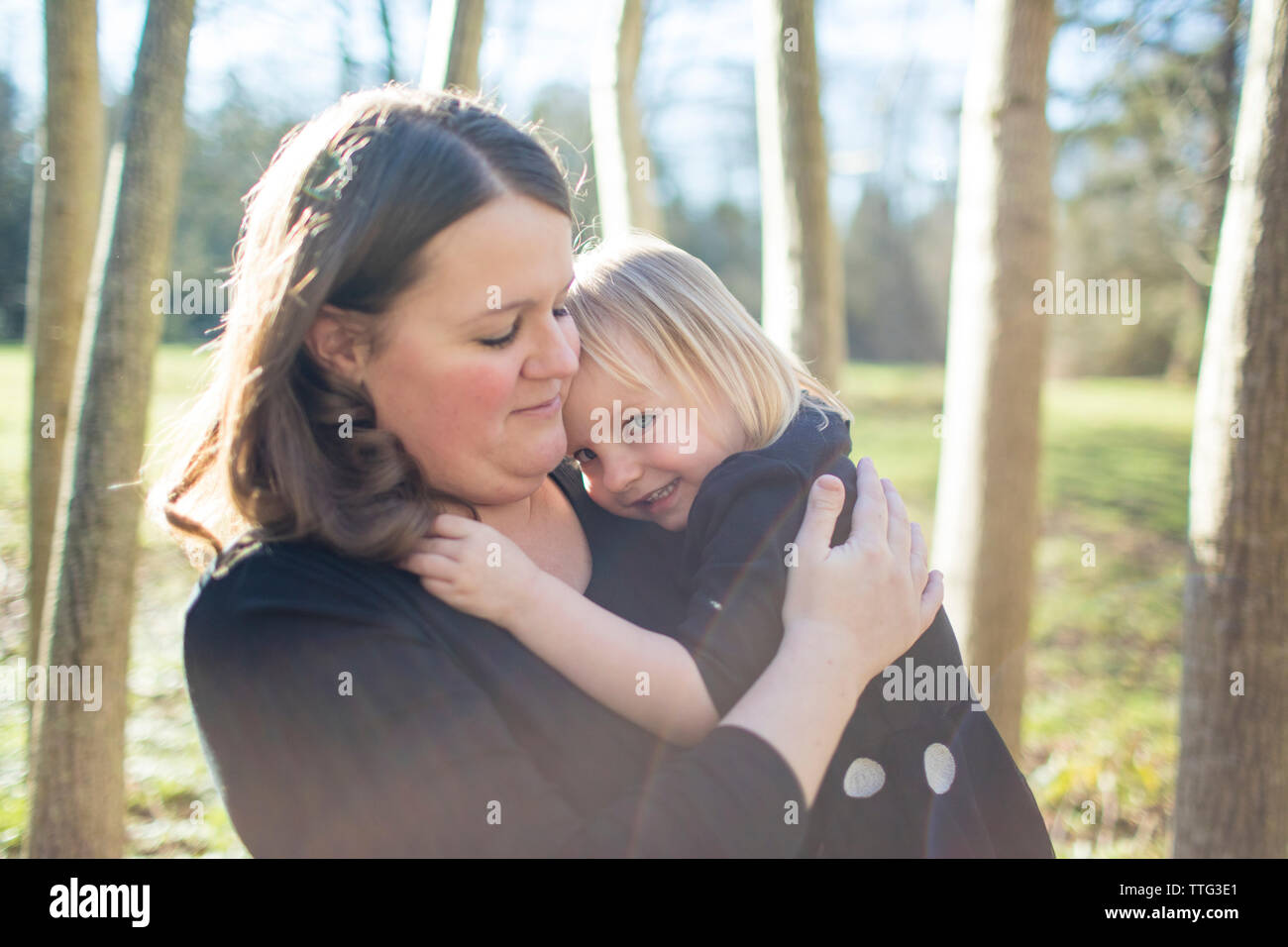 mother holding daughter at nature park. Stock Photo