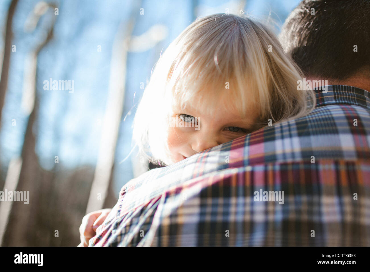 Father holding daughter, looking over his shoulder Stock Photo