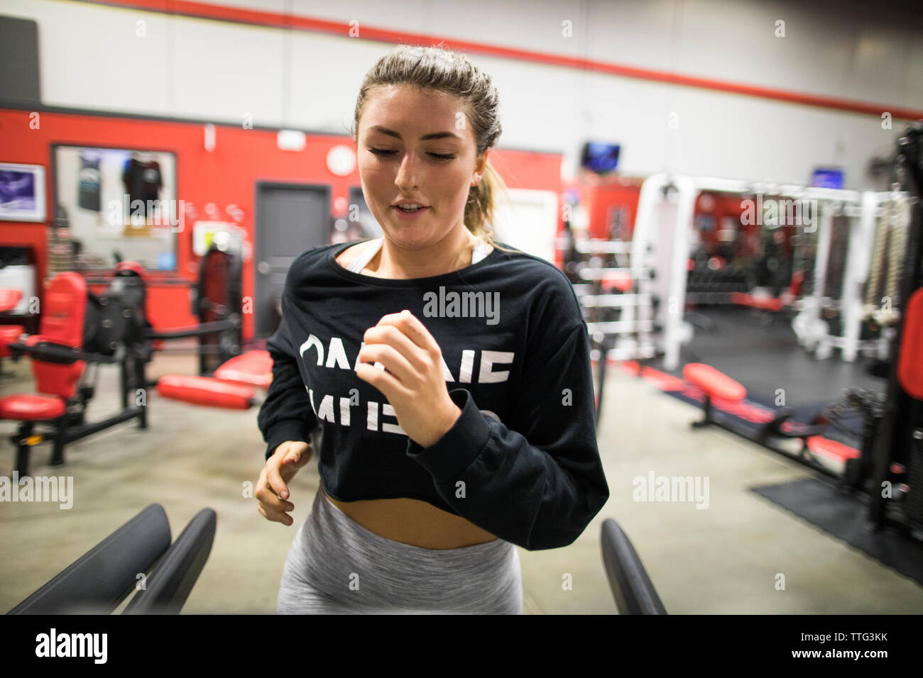 Woman looking away while exercising on treadmill in gym Stock Photo - Alamy