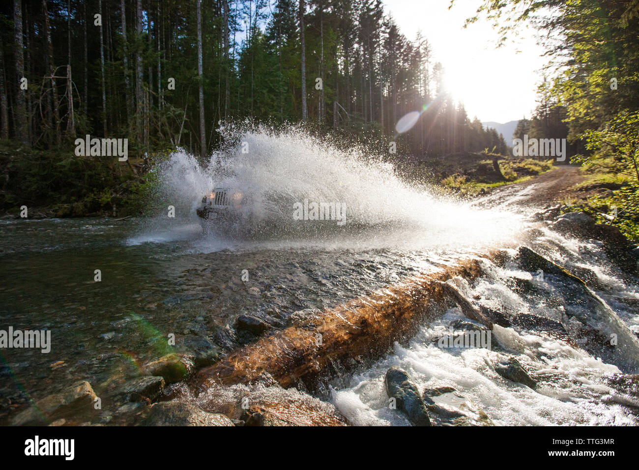 Offroad vehicle driving through river in British Columbia. Stock Photo