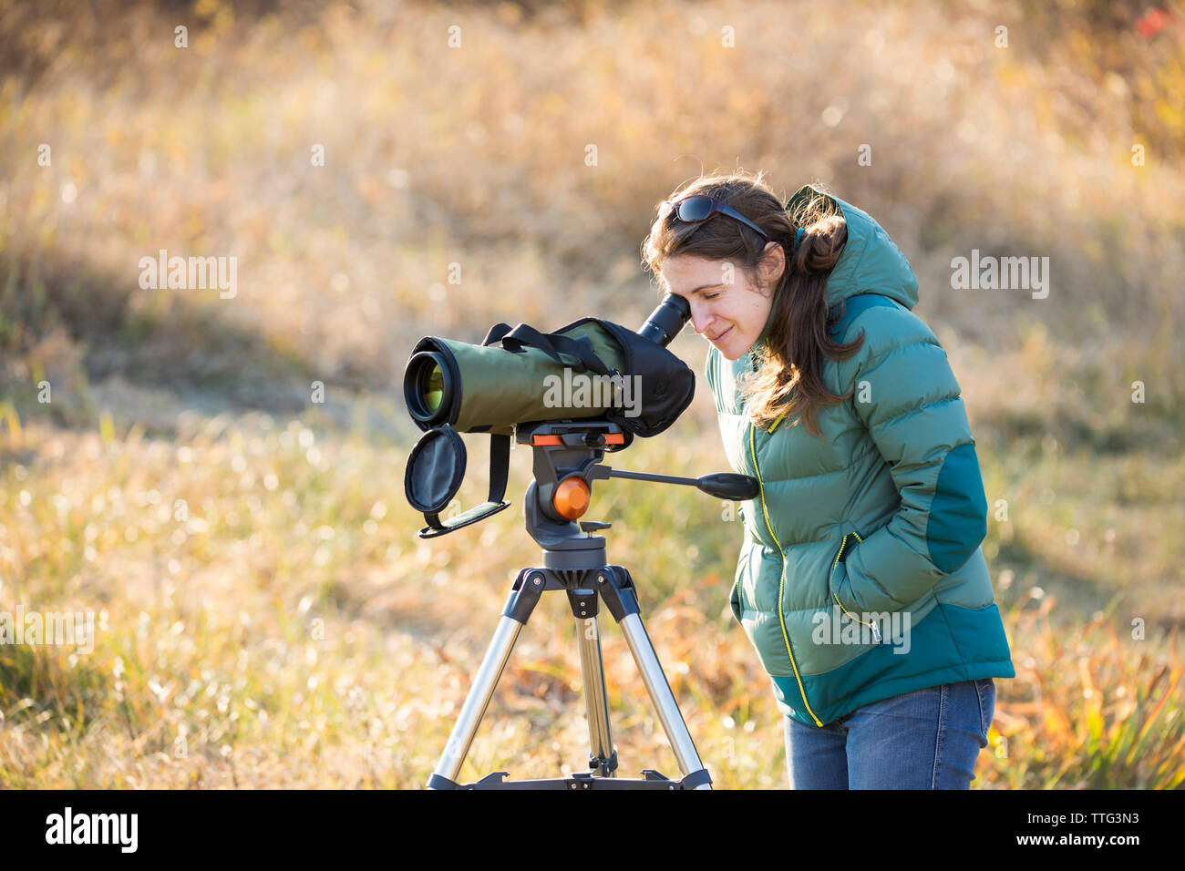 Young woman bird watching with spotting scope Stock Photo