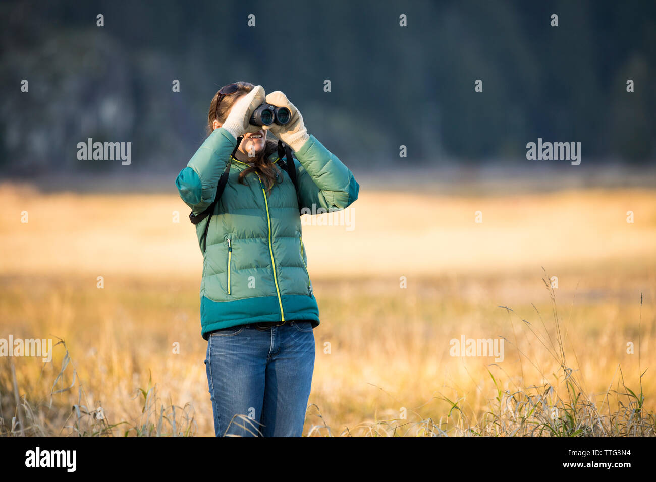 Young woman bird watching with binoculars Stock Photo