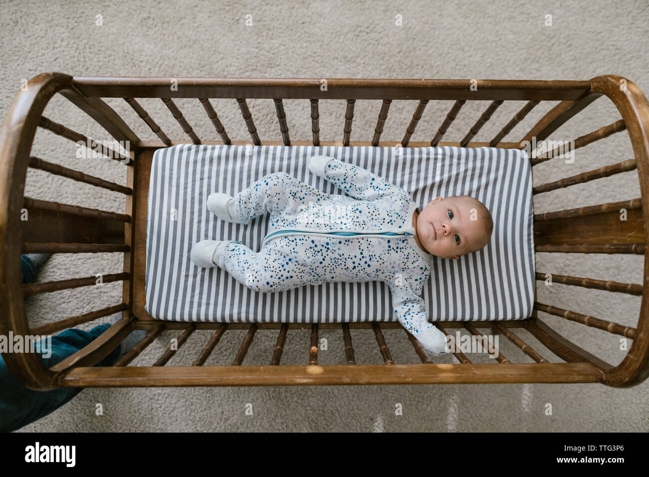 Father looking down on baby laying in crib after nap Stock Photo Alamy