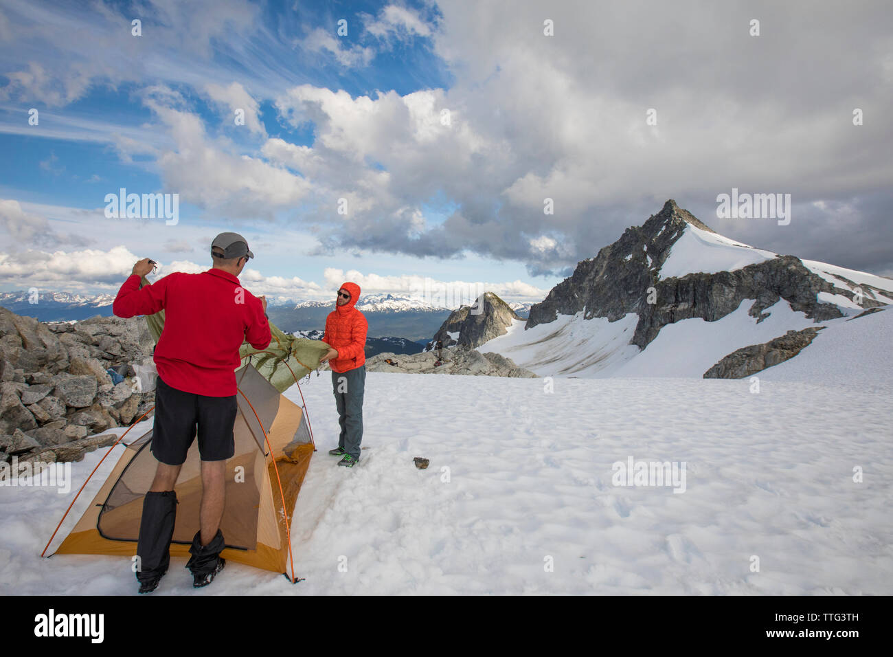 Two men set up their tent on a glacier below Cypress Peak, B.C. Stock Photo