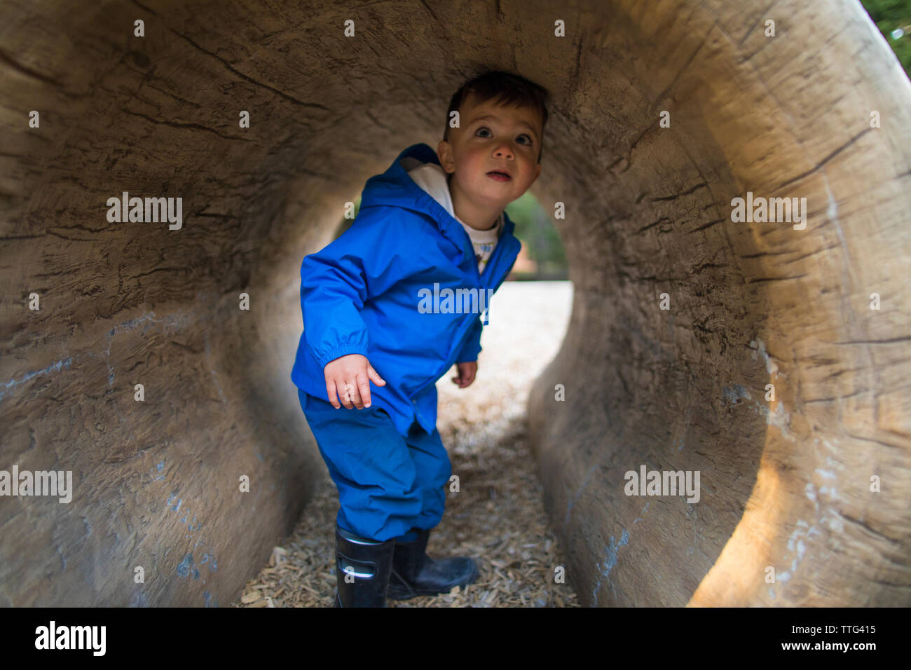 Young boy playing in tunnel in playground Stock Photo