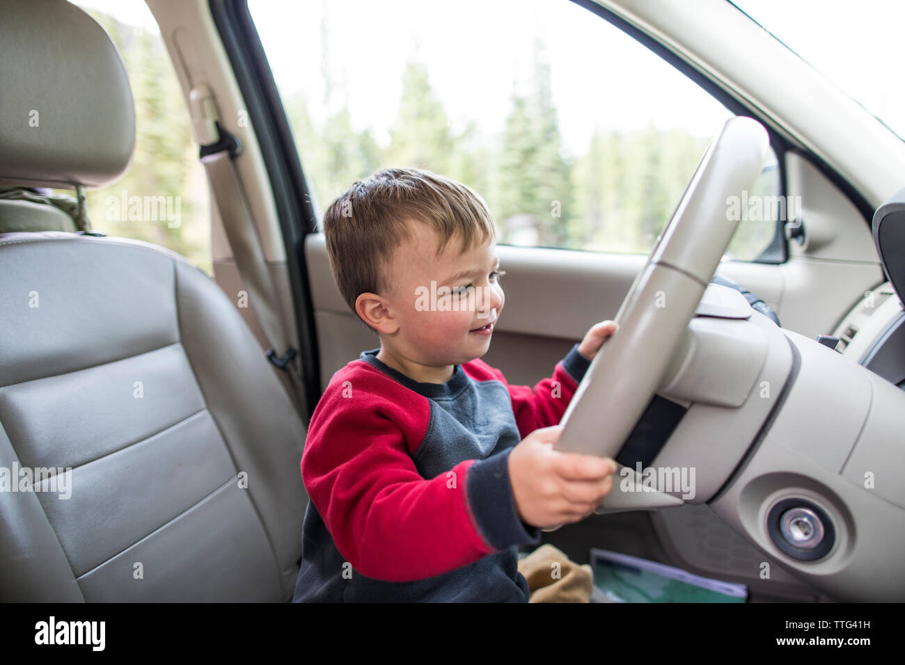 Little boy pretending to drive car Stock Photo