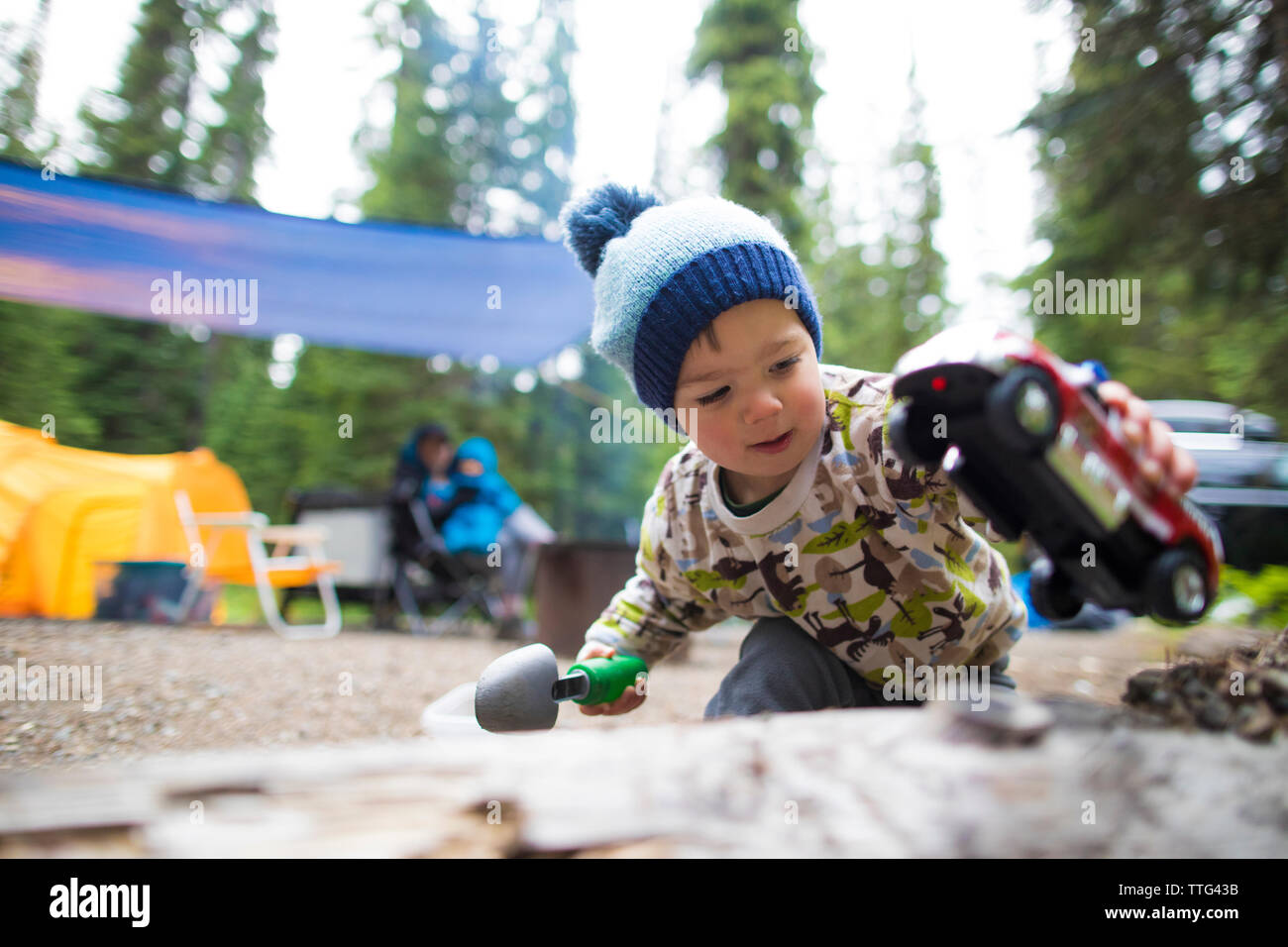 Toddler playing with truck and shovel outdoors. Stock Photo