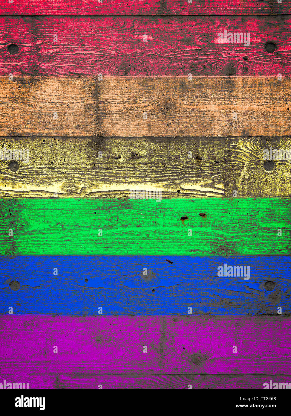 Rainbow colored spectrum gay pride background on textured layered wood grain textured concrete wall Stock Photo