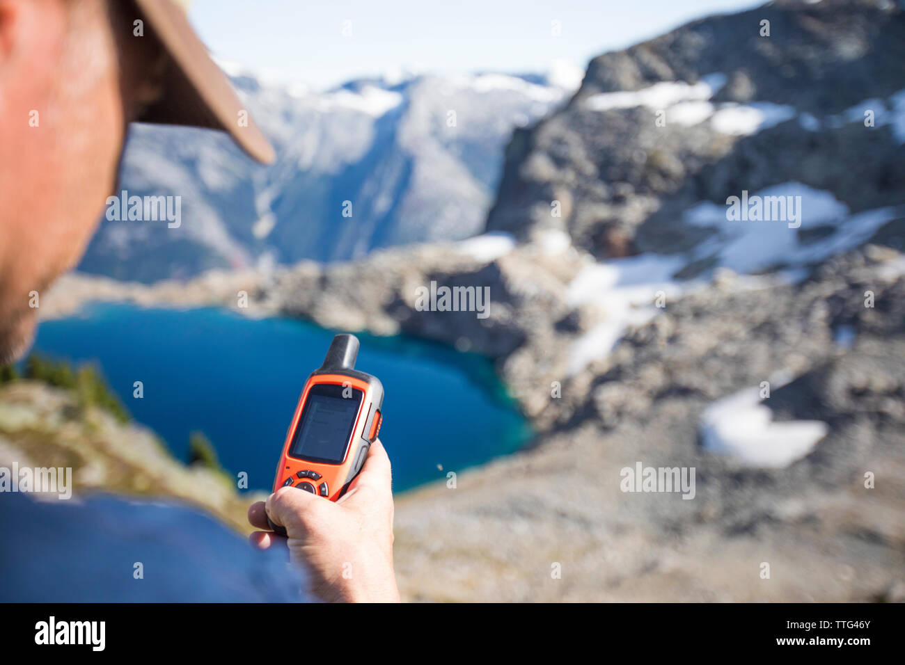 Mountaineer sends a safety message via a satellite communicator Stock Photo