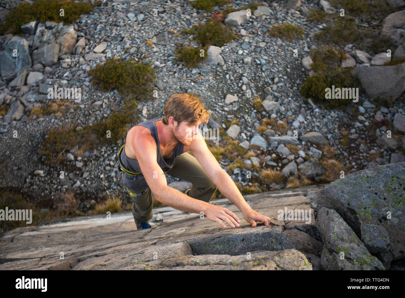 High angle view of millennial man bouldering on rock face outdoors. Stock Photo