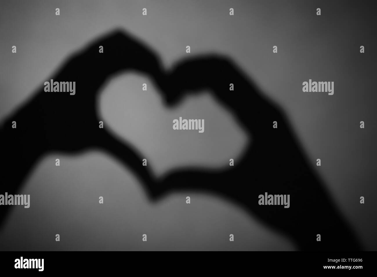 Hand shaped heart on dark background Stock Photo