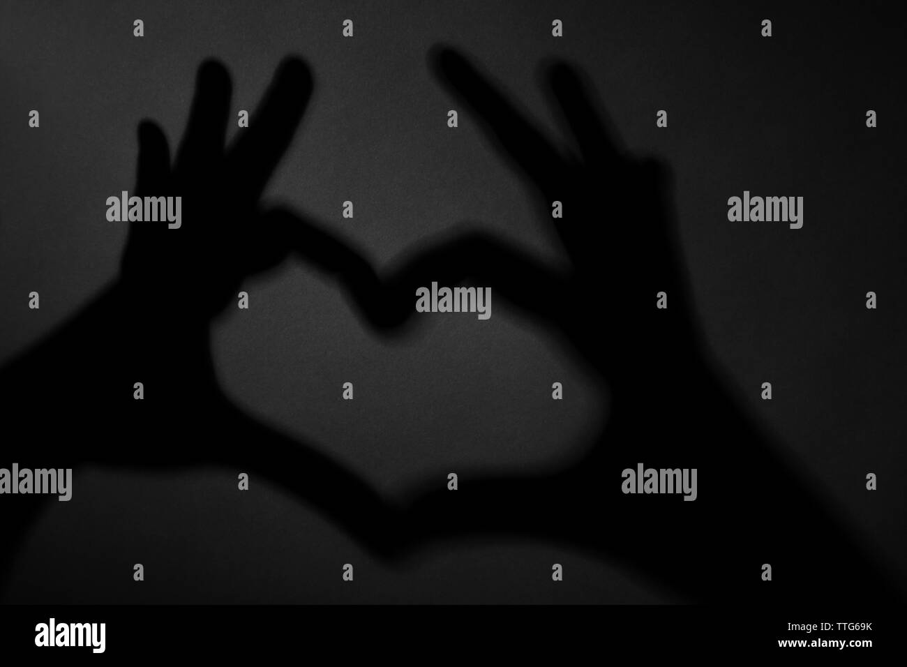 Hand shaped heart on dark background Stock Photo