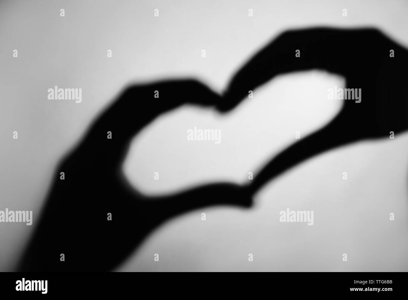 Hand shaped heart on grey background Stock Photo