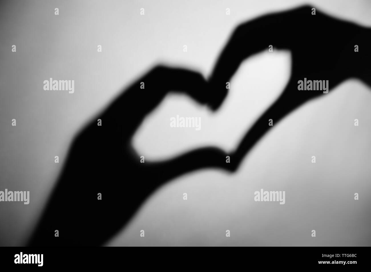 Hand shaped heart on grey background Stock Photo