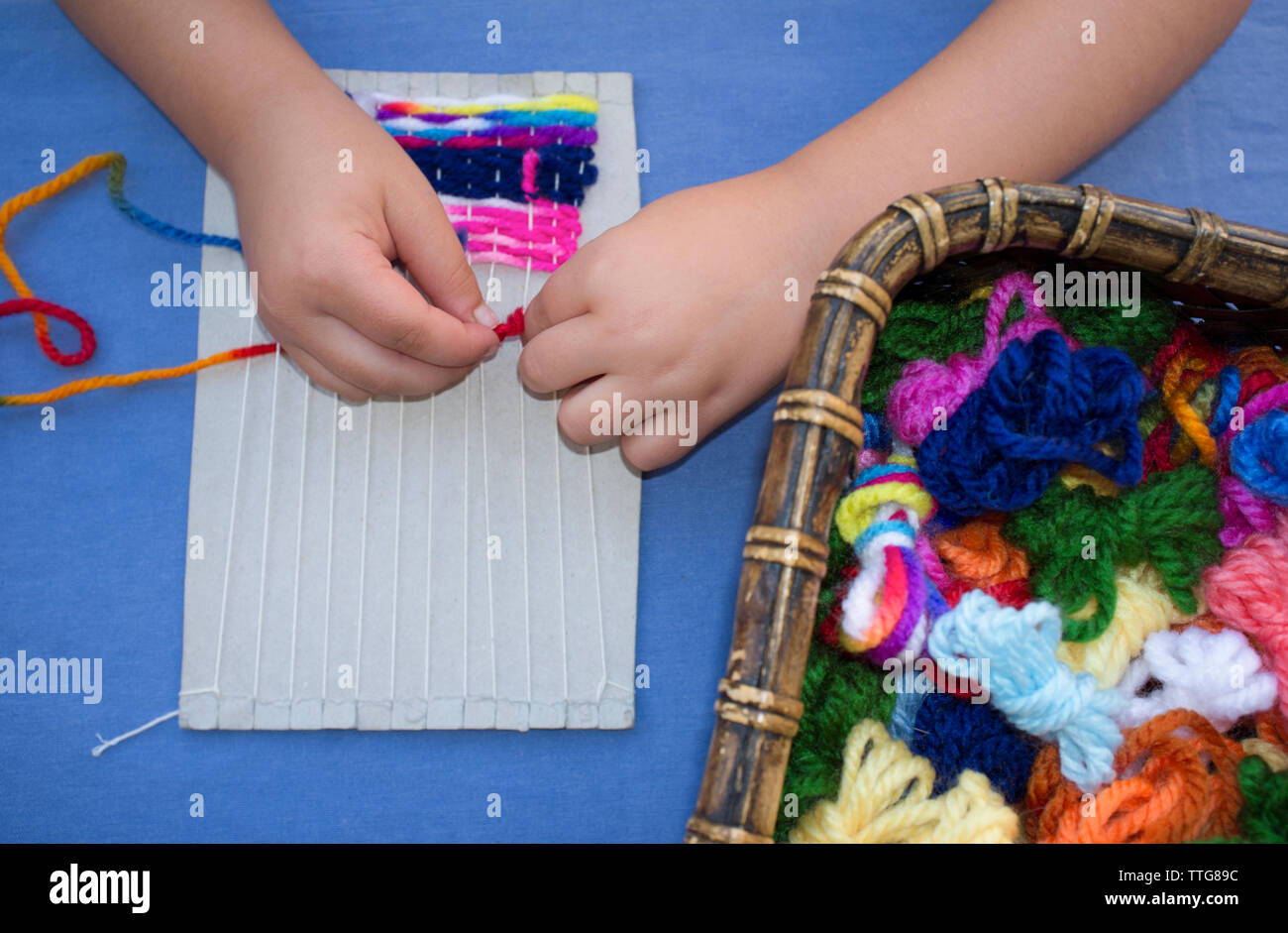 Child girl learning to use cardboard weaving loom Stock Photo Alamy
