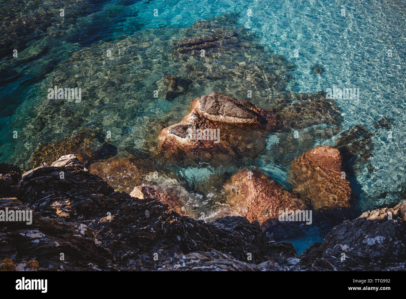 massive stones under turquiose waters in the sea Stock Photo