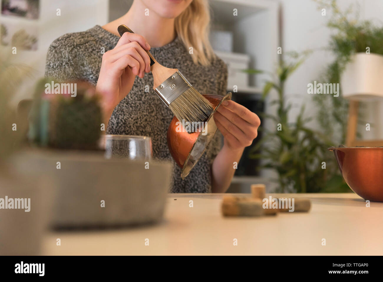 Midsection of businesswoman brushing metallic bowl to make concrete pot office Stock Photo