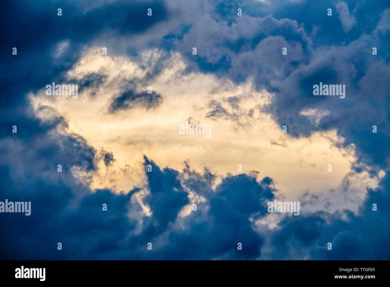 Break in fast-moving storm clouds at sunset near the start of summer Stock Photo