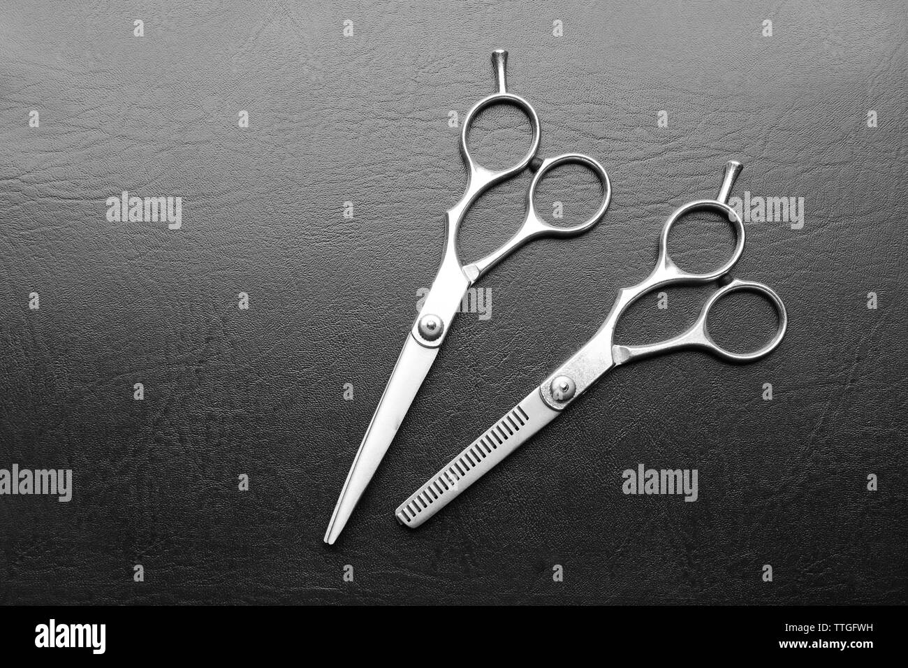 Professional metal scissors on a dark grey surface, top view Stock
