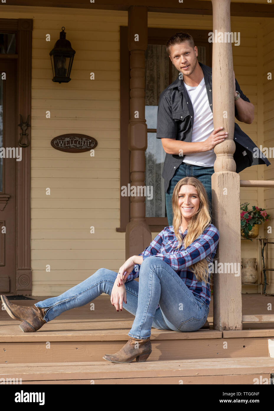 Western wear young married couple on porch of house Stock Photo