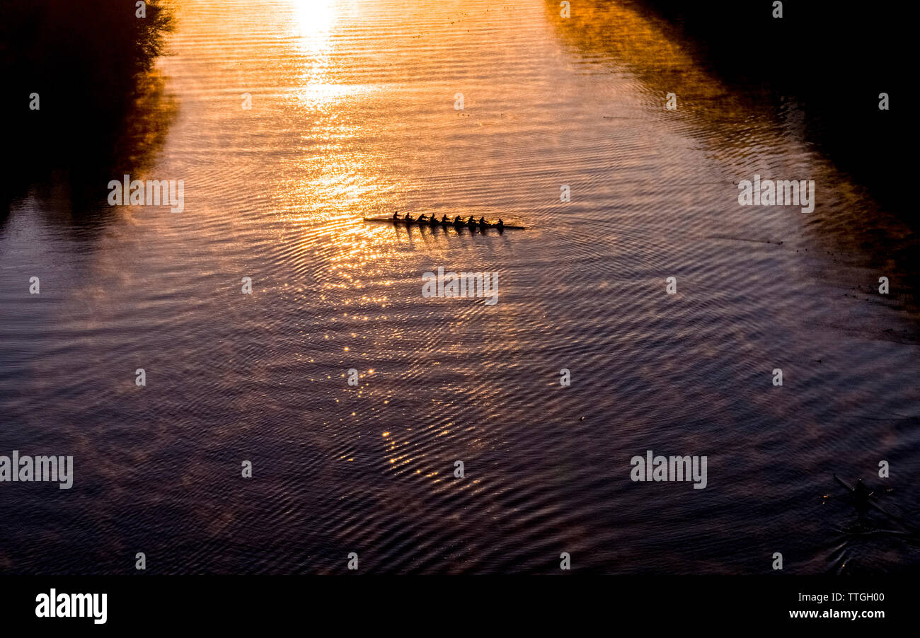High angle distant view of people sculling on Lady Bird Lake during sunrise Stock Photo