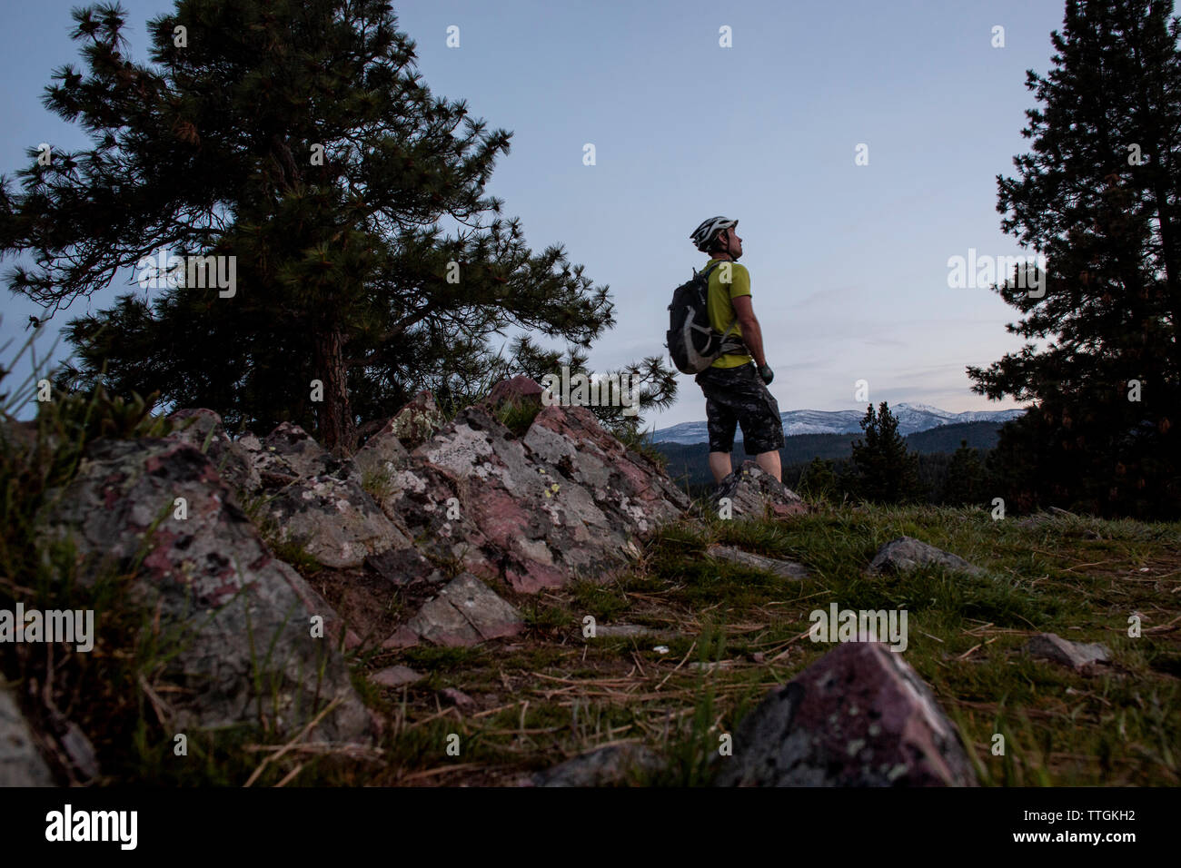 A male mountain biker at dusks takes in the view of Lolo Peak, Montana Stock Photo